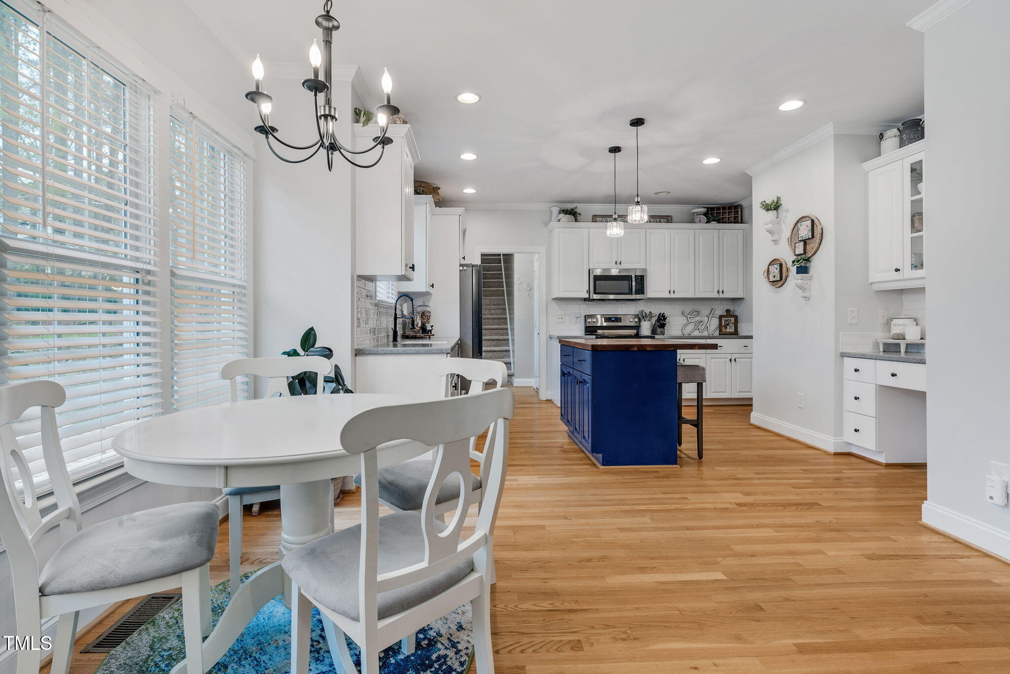 1113 Colonial Club Road Wake Forest, NC 27587 - Photo 16 of 41 a large kitchen with stainless steel appliances kitchen island granite countertop a table chairs and a refrigerator