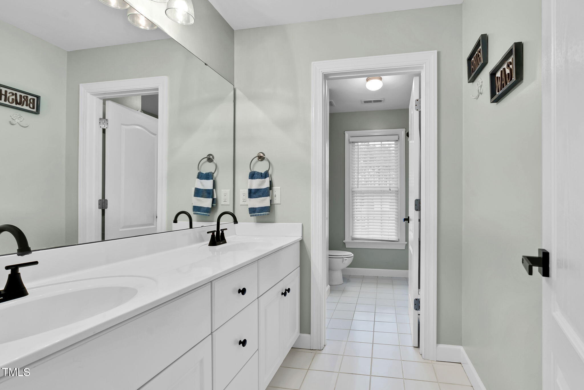 1113 Colonial Club Road Wake Forest, NC 27587 - Photo 27 of 41 a bathroom with a double vanity sink and mirror
