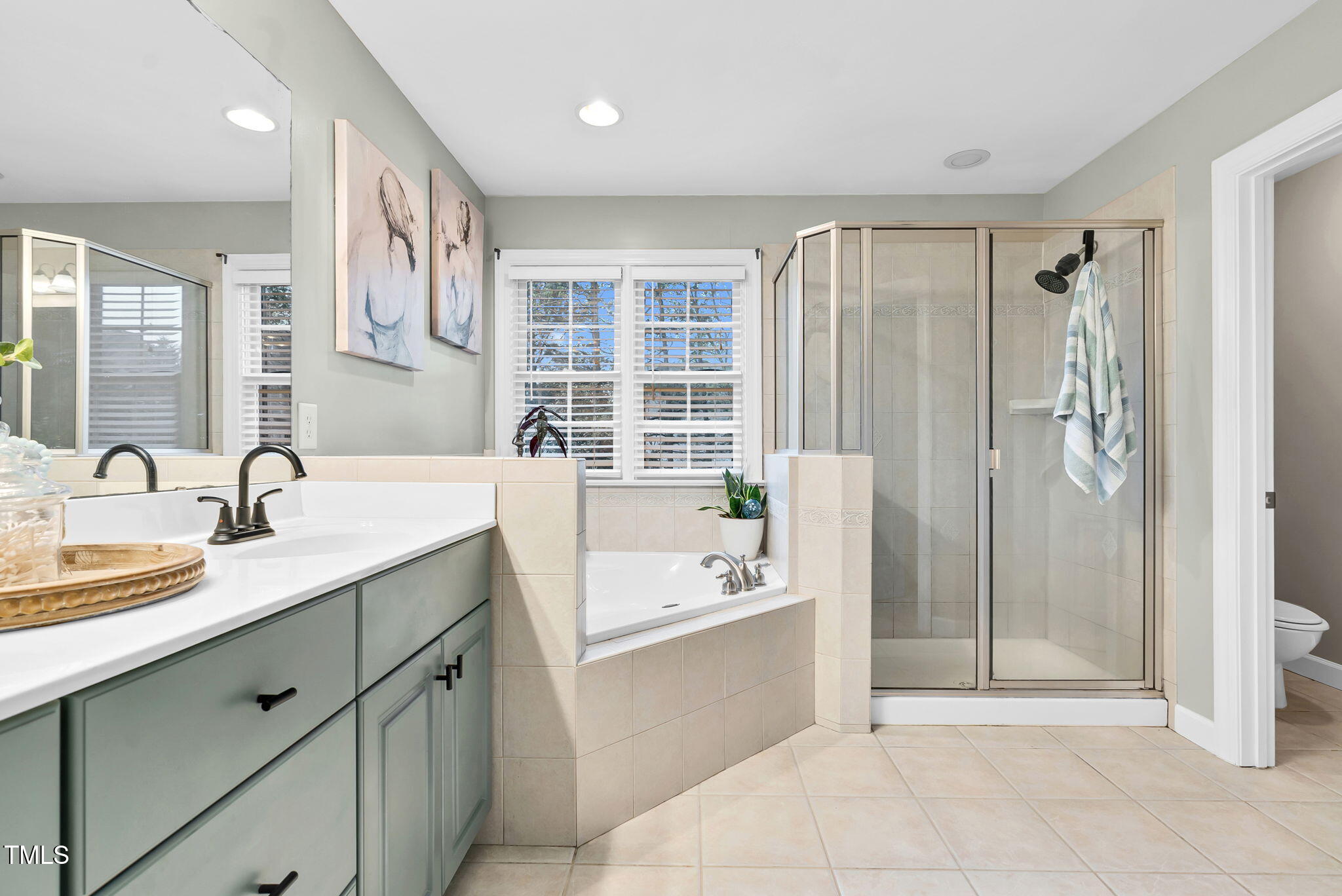 1113 Colonial Club Road Wake Forest, NC 27587 - Photo 34 of 41 a bathroom with a tub sink and mirror