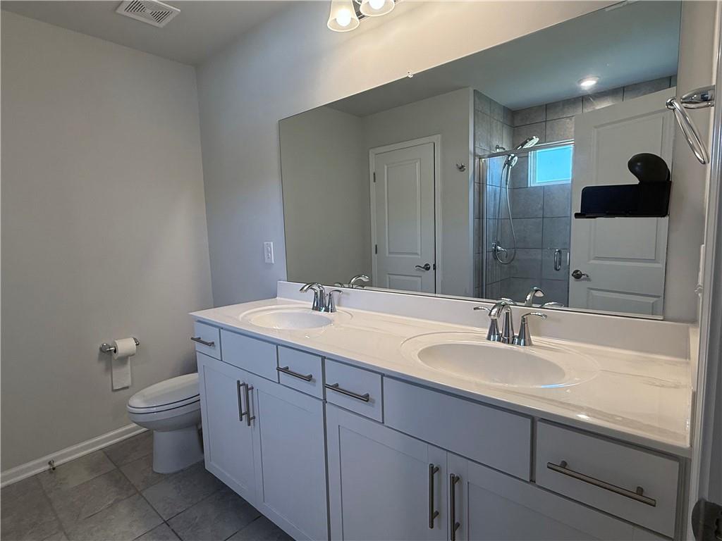 1543 Maston Road Auburn, GA 30011 - Photo 23 of 33 a bathroom with a double vanity sink toilet and mirror