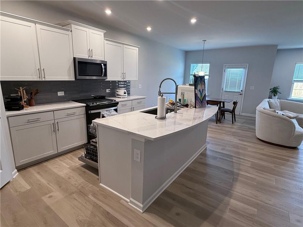 1543 Maston Road Auburn, GA 30011 - Photo 8 of 33 a living room with stainless steel appliances granite countertop a sink a stove top oven a counter space and cabinets