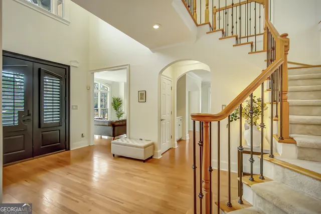 a view of a backyard with lawn chairs under a large tree