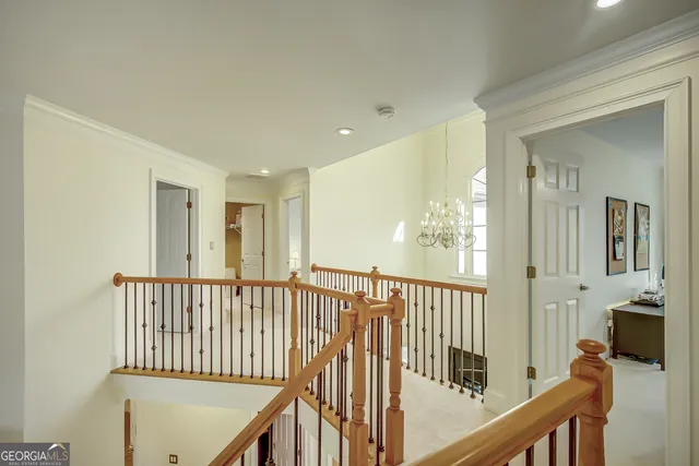 a view of a patio with table and chairs under an umbrella with large trees