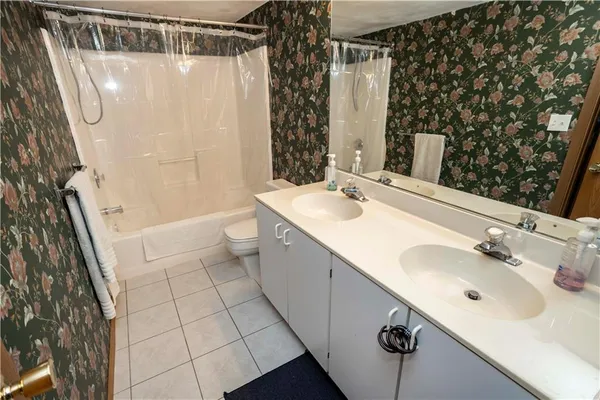 a bathroom with a sink and mirror with bathtub