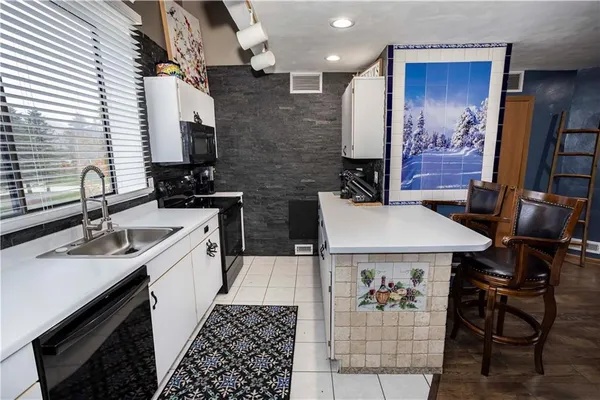 a kitchen with stainless steel appliances kitchen island granite countertop a sink stove and refrigerator