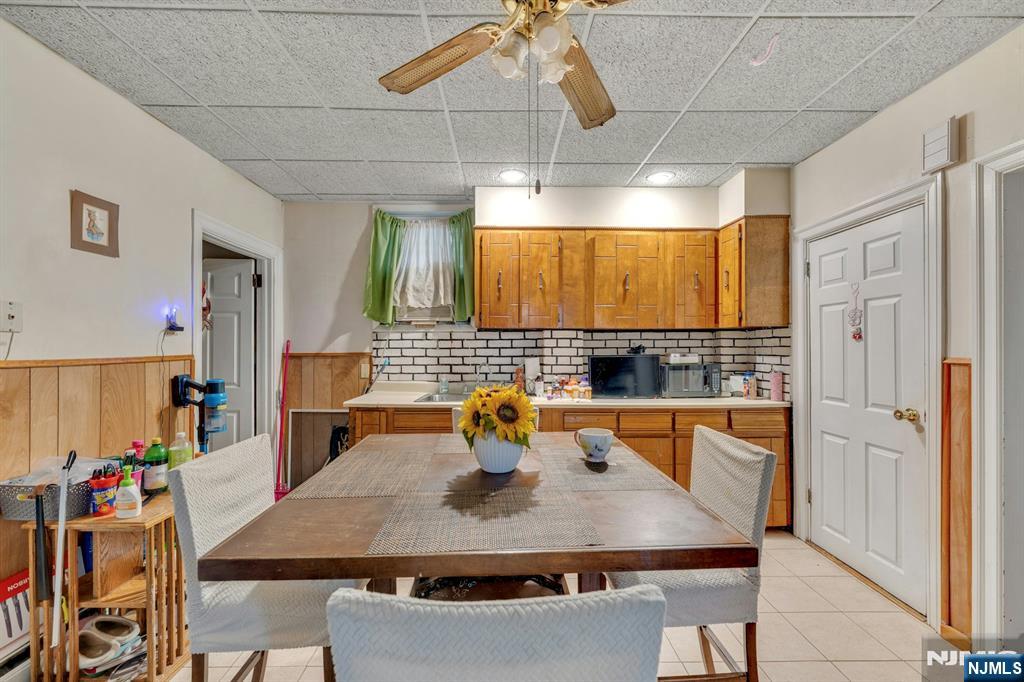 79 Washington Street Harrison, NJ 07029 - Photo 5 of 25 a kitchen with a table chairs and a refrigerator
