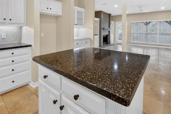 a kitchen with granite countertop a sink a stove and cabinets