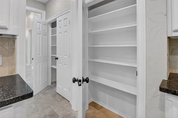 a kitchen with white cabinets and black appliances