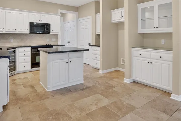 a view of a kitchen with white cabinets