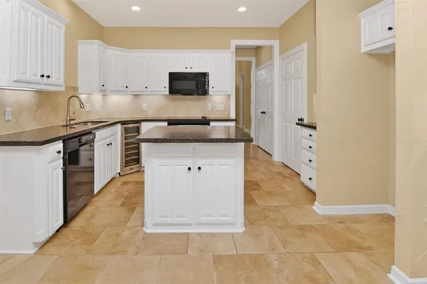 a kitchen with stainless steel appliances granite countertop a stove a sink and a white refrigerator