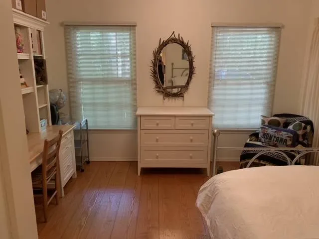 a bed sitting in a spacious bedroom next to a window