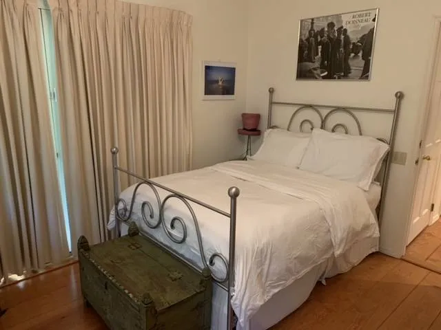a bedroom with a bed and a flat tv screen on the dresser