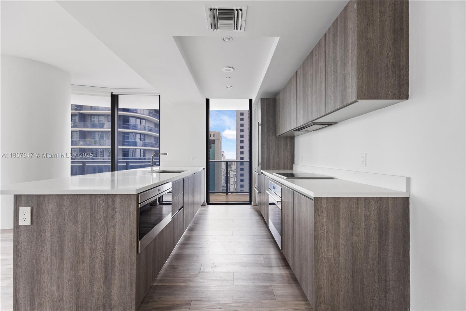801 South Miami Avenue, Unit 2201 Miami, FL 33131 - Photo 15 of 37 a kitchen with counter top space and wooden floor