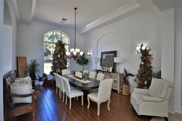 a view of a dining room with furniture wooden floor and chandelier