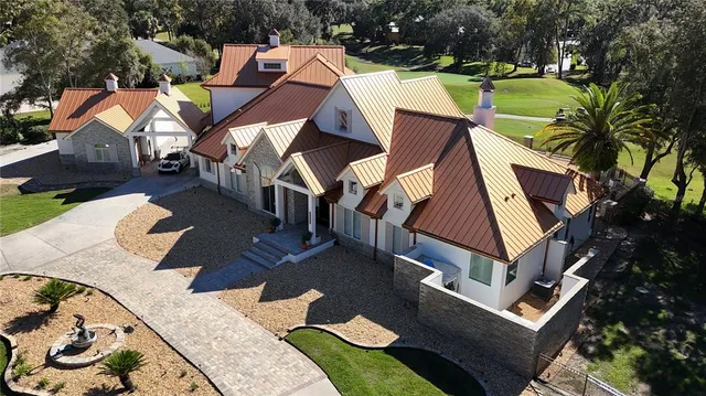 an aerial view of a house with garden space and trees