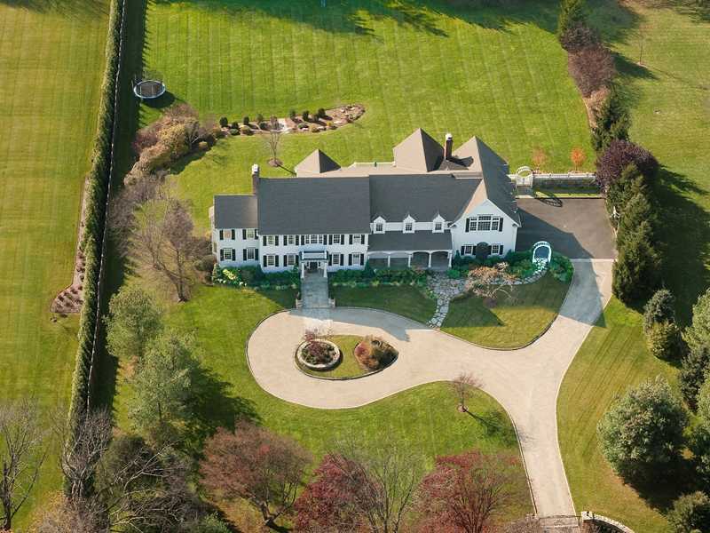 an aerial view of a house with swimming pool and garden