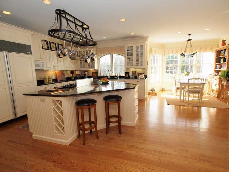 359 Mansfield Avenue Darien, CT 06820 - Photo 7 of 25 a kitchen with stainless steel appliances granite countertop a table chairs stove and wooden floor