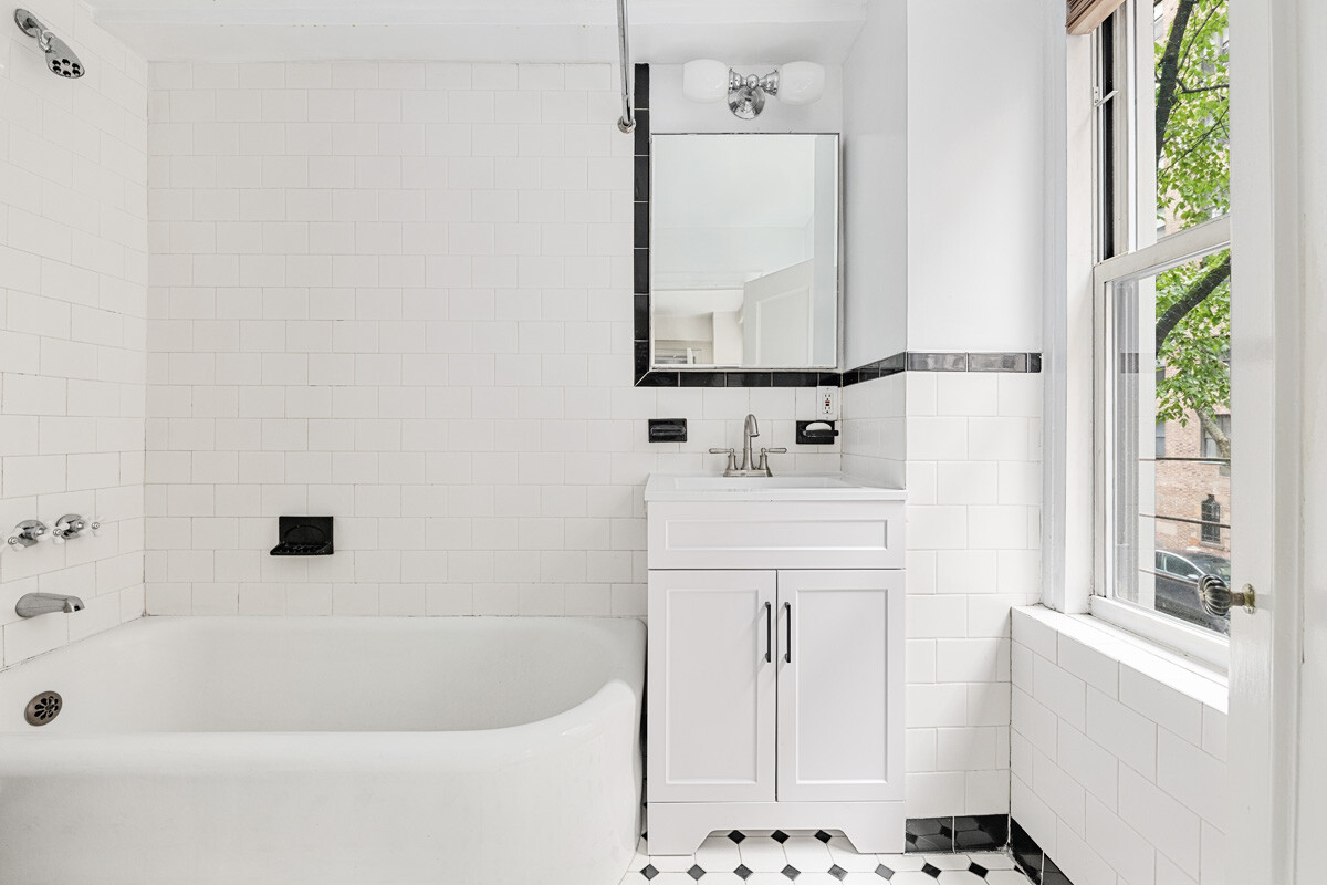 215 East 73rd Street, Unit 2A Manhattan, NY 10021 - Photo 10 of 20 a bathroom with a sink a vanity and a bathtub