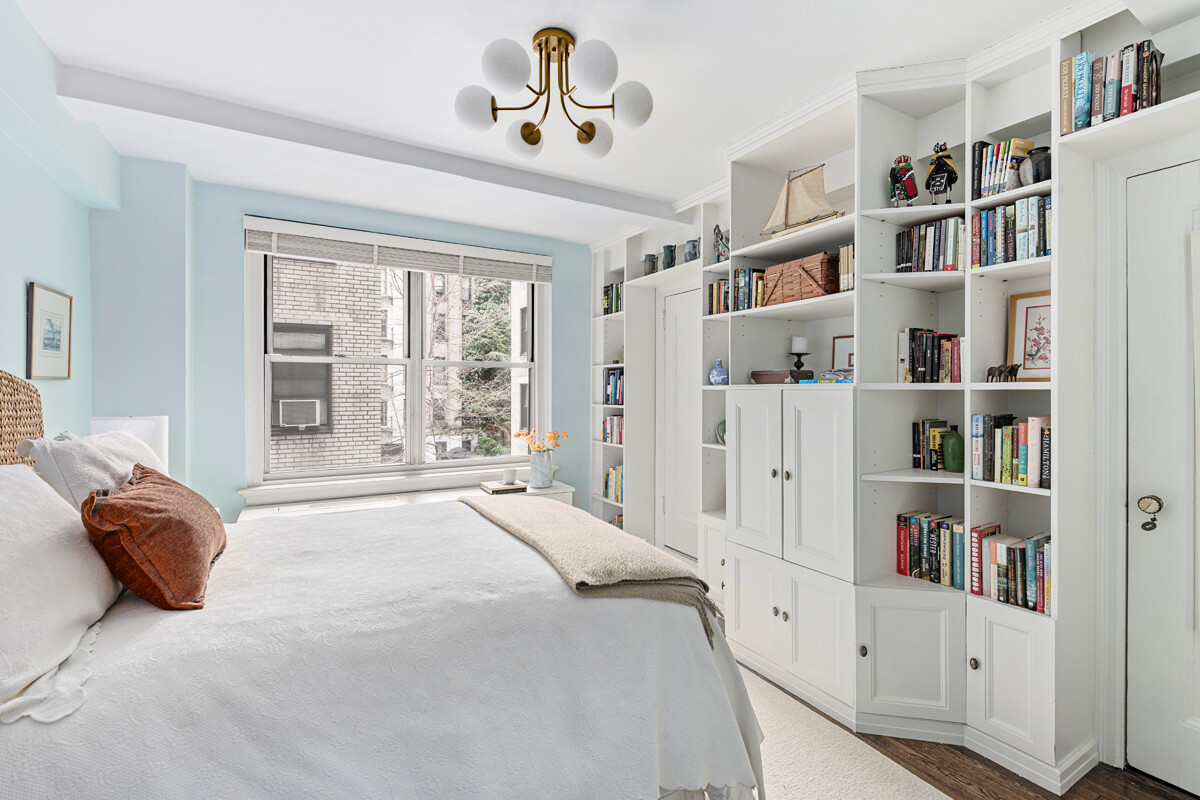 215 East 73rd Street, Unit 2A Manhattan, NY 10021 - Photo 12 of 20 a bedroom with a bed and a book shelf