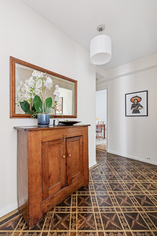 215 East 73rd Street, Unit 2A Manhattan, NY 10021 - Photo 7 of 20 a hallway with a sink and a large mirror