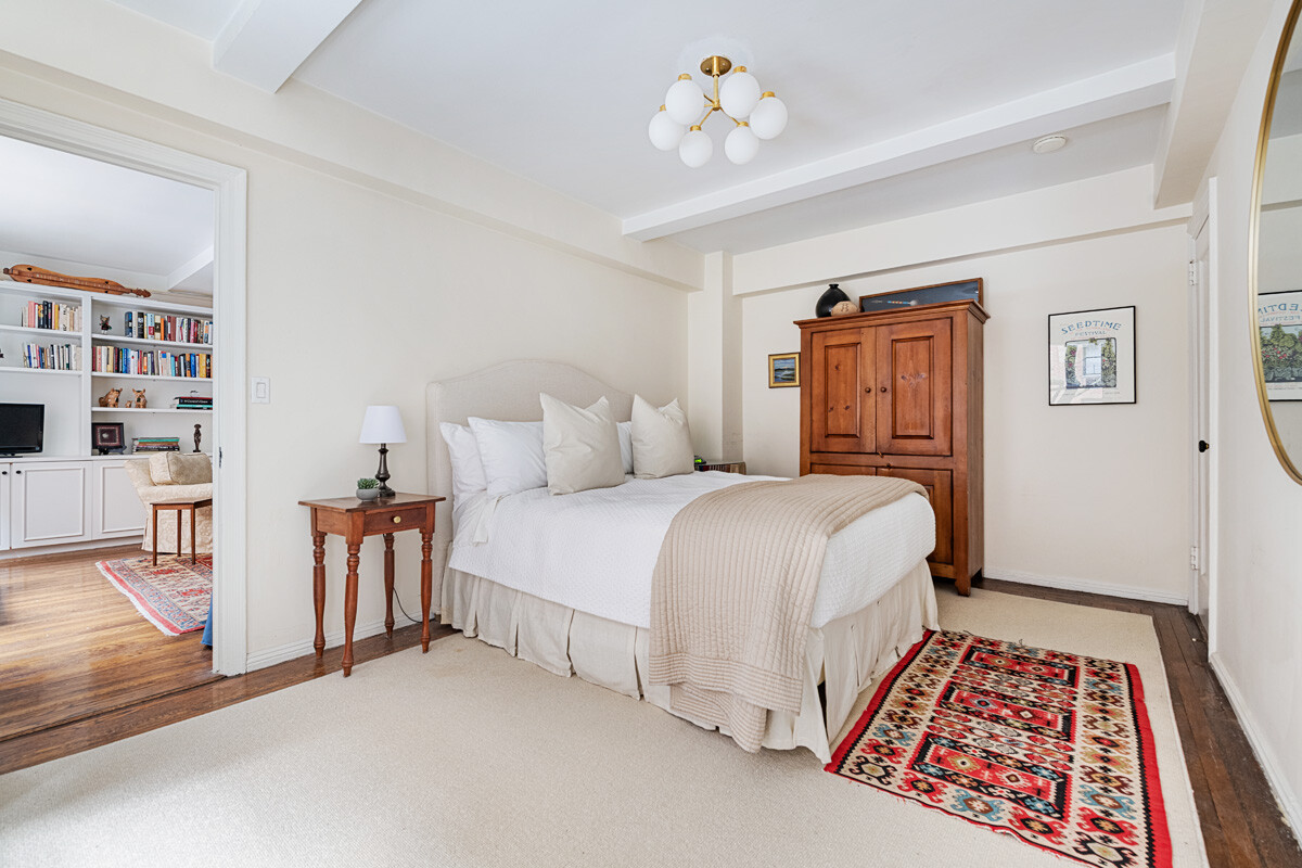 215 East 73rd Street, Unit 2A Manhattan, NY 10021 - Photo 9 of 20 a bedroom with a bed and a bookshelf