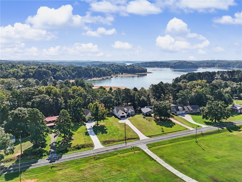 An aerial view showcases the home’s setting near Lake Hartwell, with the lake just beyond the property and mature trees surrounding the neighborhood.