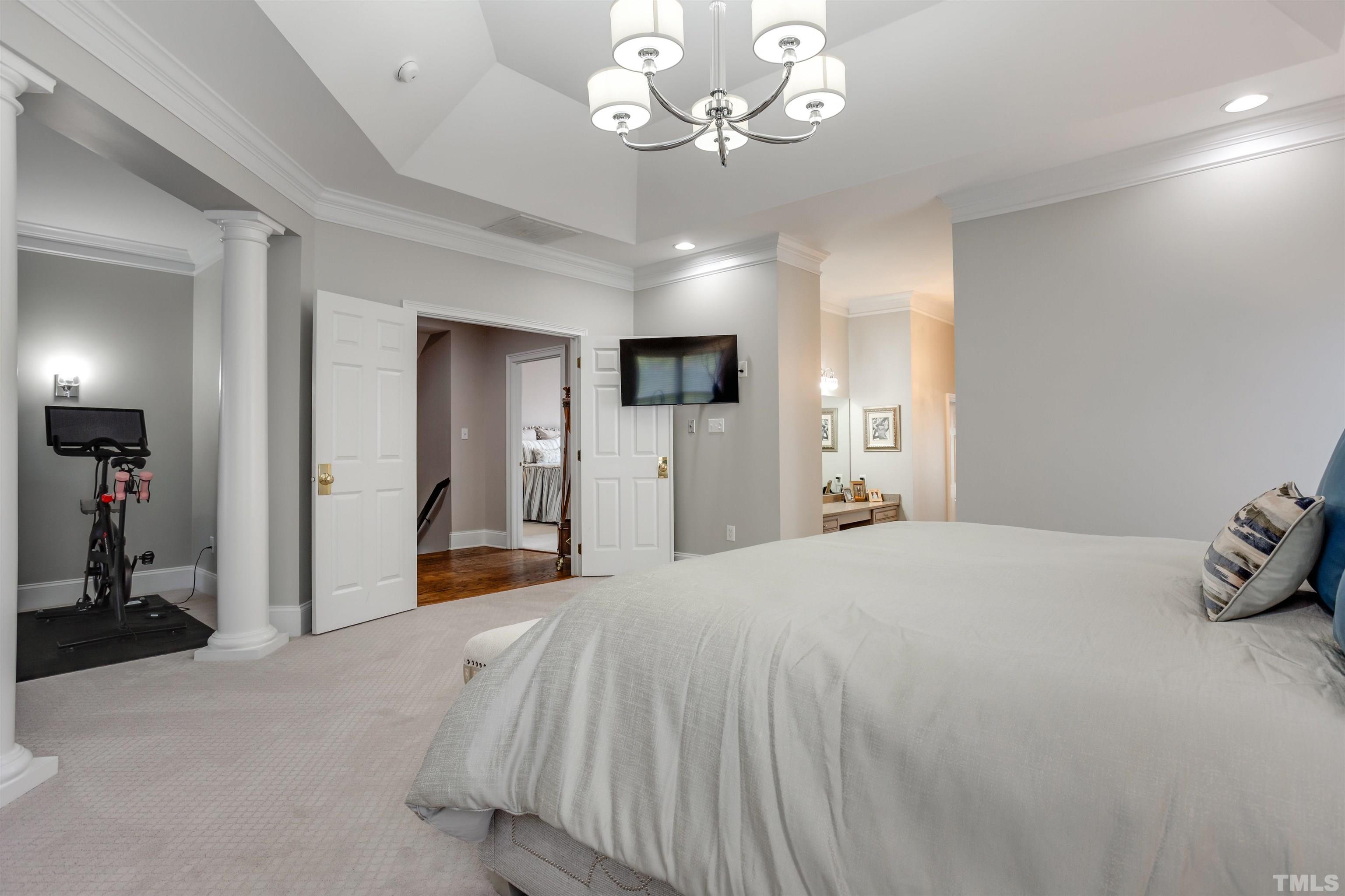 11313 Ridgegate Drive Raleigh, NC 27617 - Photo 59 of 82 a bedroom with a bed and a chandelier