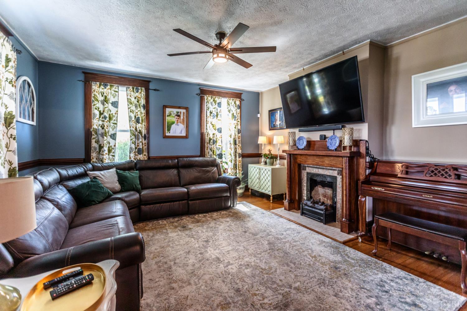 151 Burke Street Appomattox, VA 24522 - Photo 13 of 75 a living room with furniture a flat screen tv and a fireplace