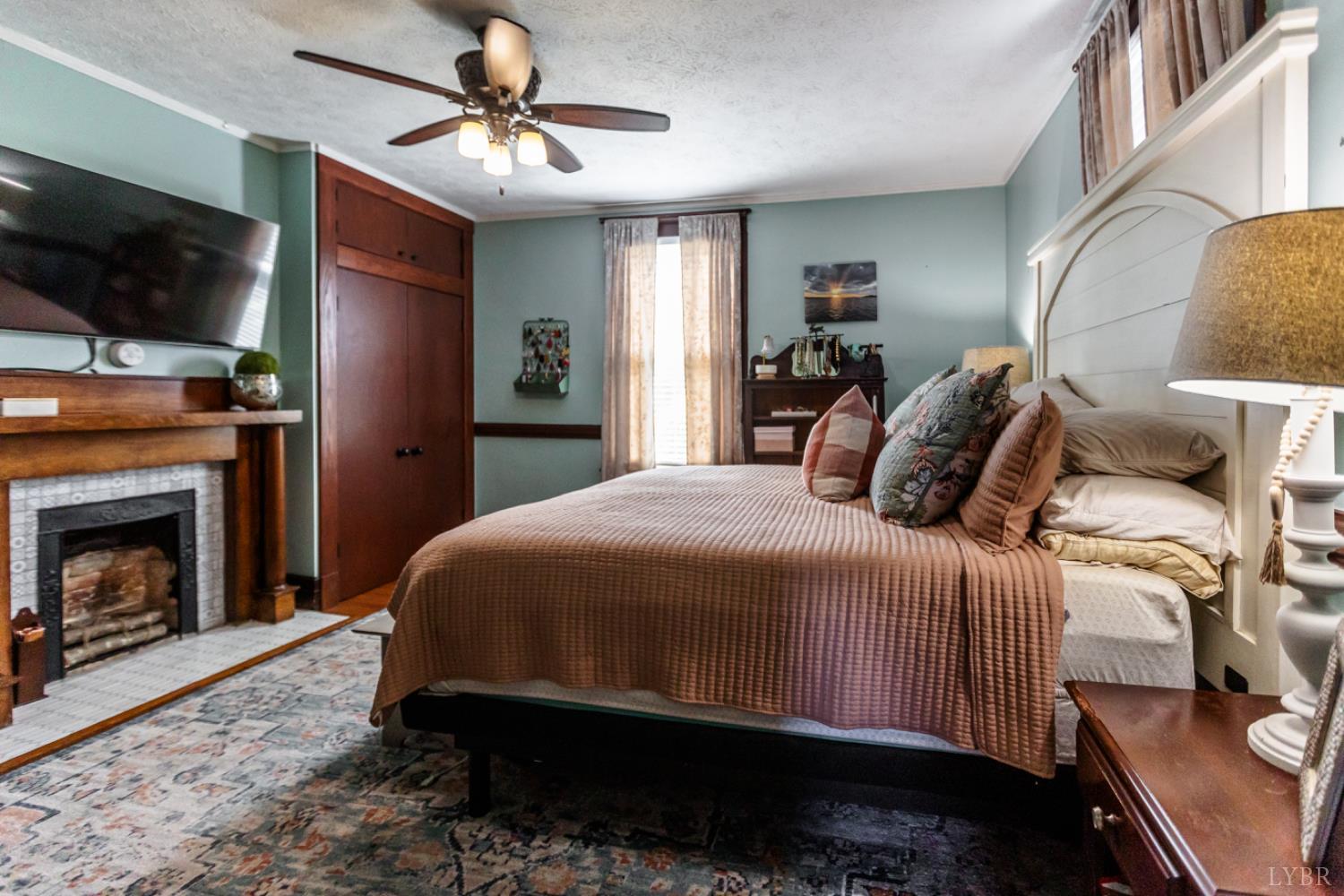 151 Burke Street Appomattox, VA 24522 - Photo 36 of 75 a bedroom with a bed a flat screen tv and a fireplace