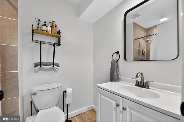 a bathroom with a sink mirror and toilet