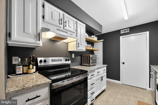 a kitchen with stainless steel appliances granite countertop a stove and a refrigerator