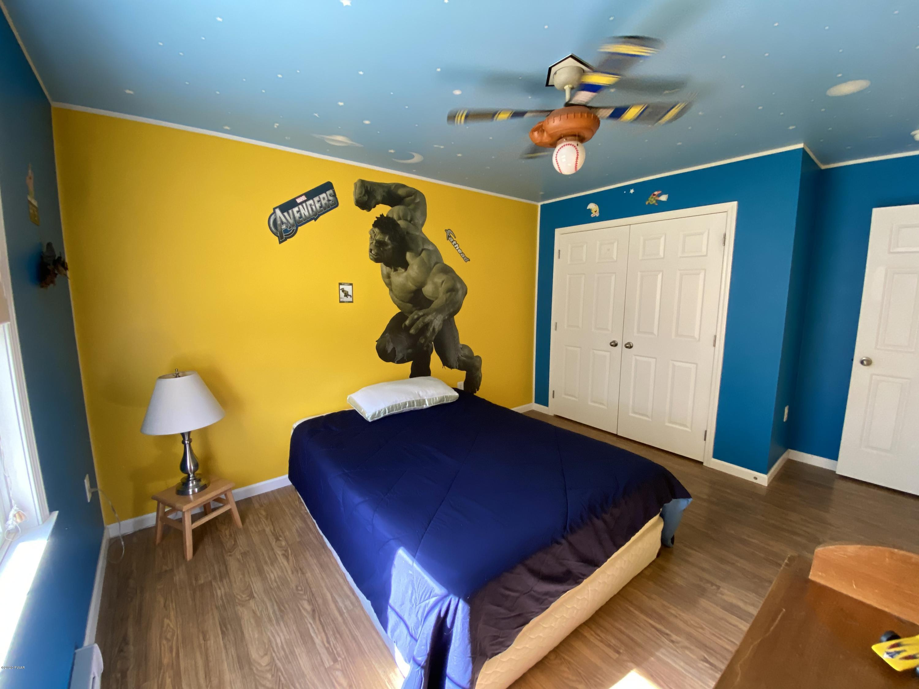 283 Mill Brook Road Waymart, PA 18472 - Photo 10 of 30 a bedroom with a bed and a chandelier