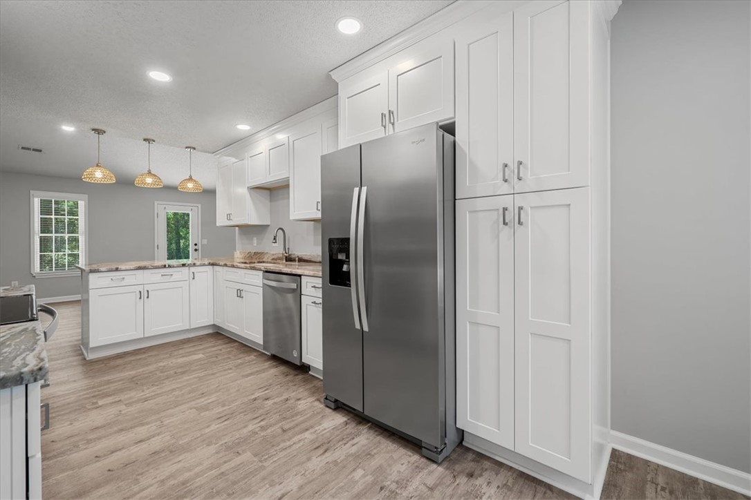 212 Blue Ridge Drive Clemson, SC 29631 - Photo 11 of 33 A contemporary kitchen features bright white cabinetry, stainless steel appliances, and a seamless flow of natural light.