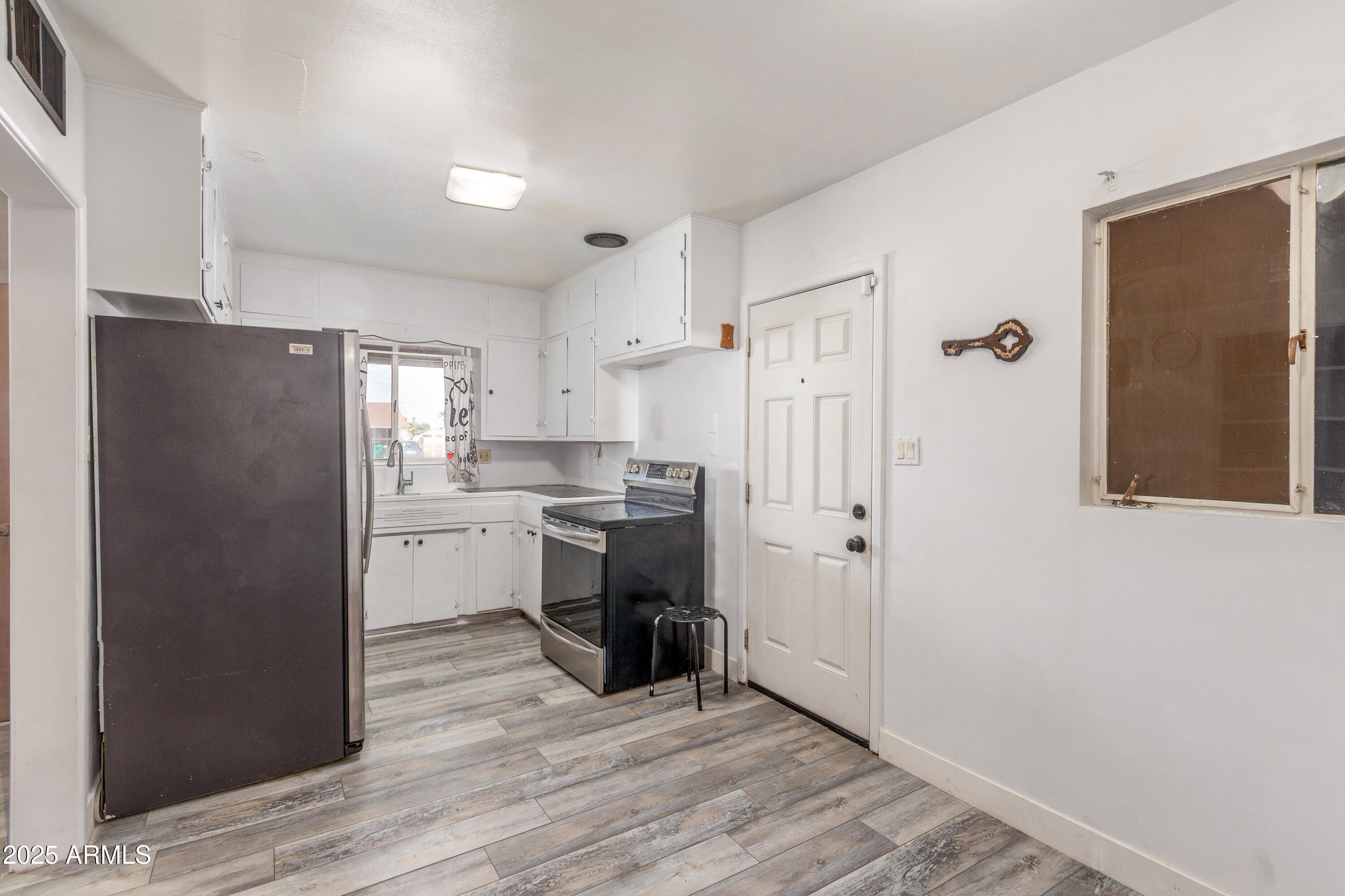 413 East 3rd Street Eloy, AZ 85131 - Photo 11 of 44 a kitchen with a refrigerator a sink and cabinets