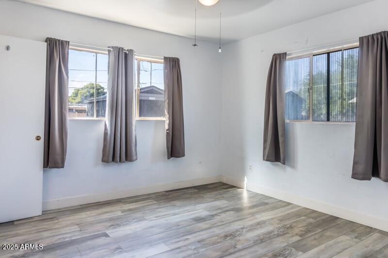 413 East 3rd Street Eloy, AZ 85131 - Photo 17 of 44 an empty room with wooden floor and a window
