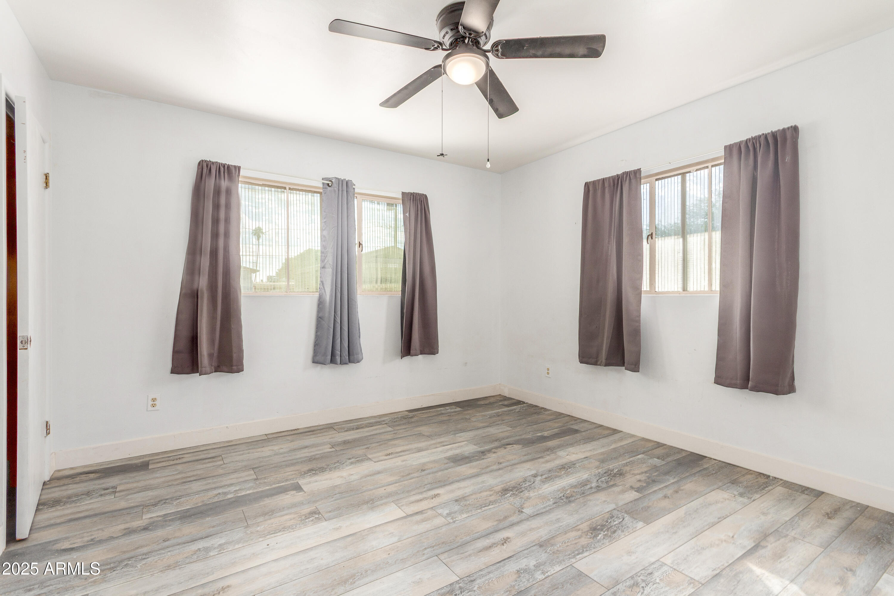 413 East 3rd Street Eloy, AZ 85131 - Photo 18 of 44 a view of an empty room with window and wooden floor