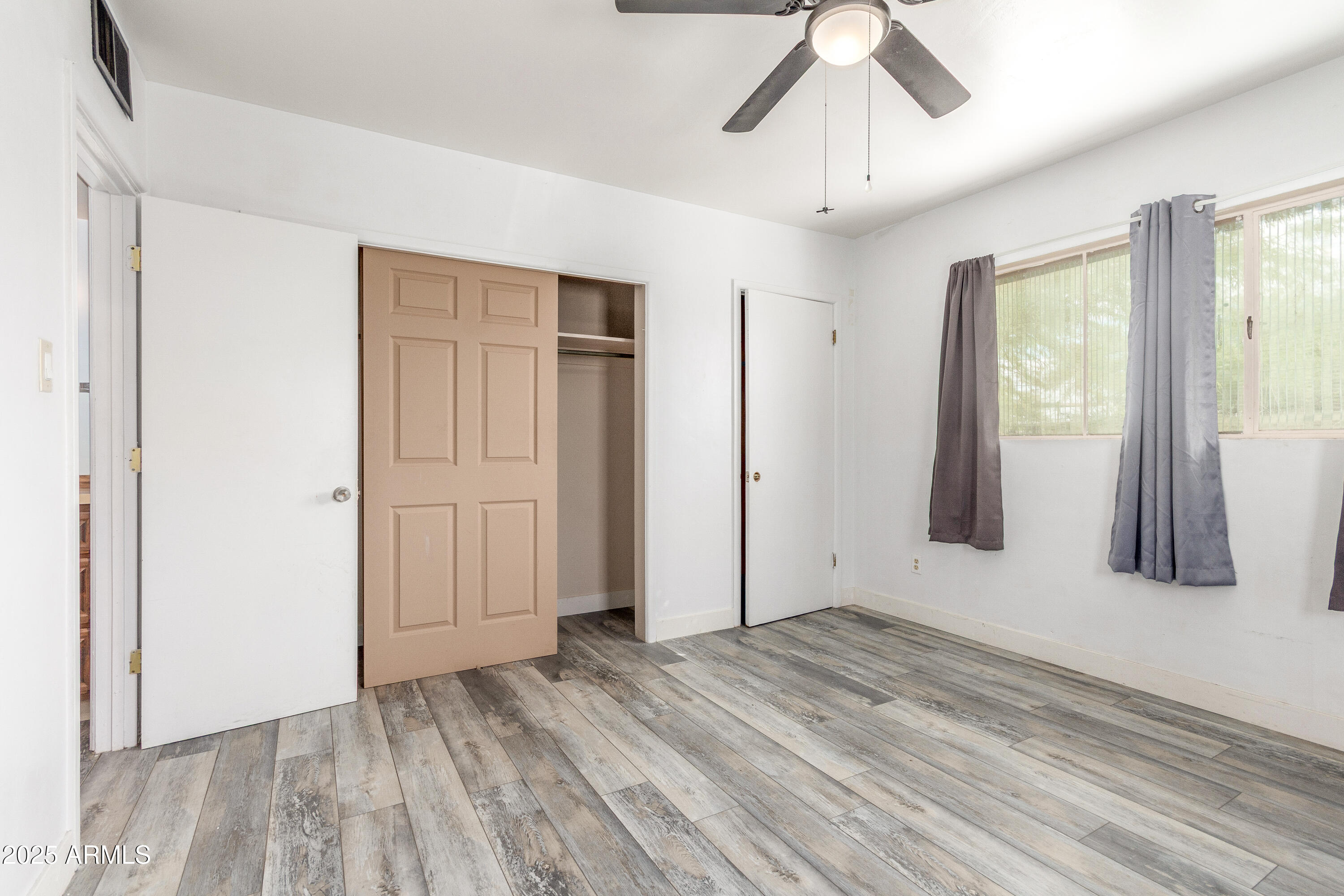 413 East 3rd Street Eloy, AZ 85131 - Photo 19 of 44 a view of an empty room with wooden floor and a window
