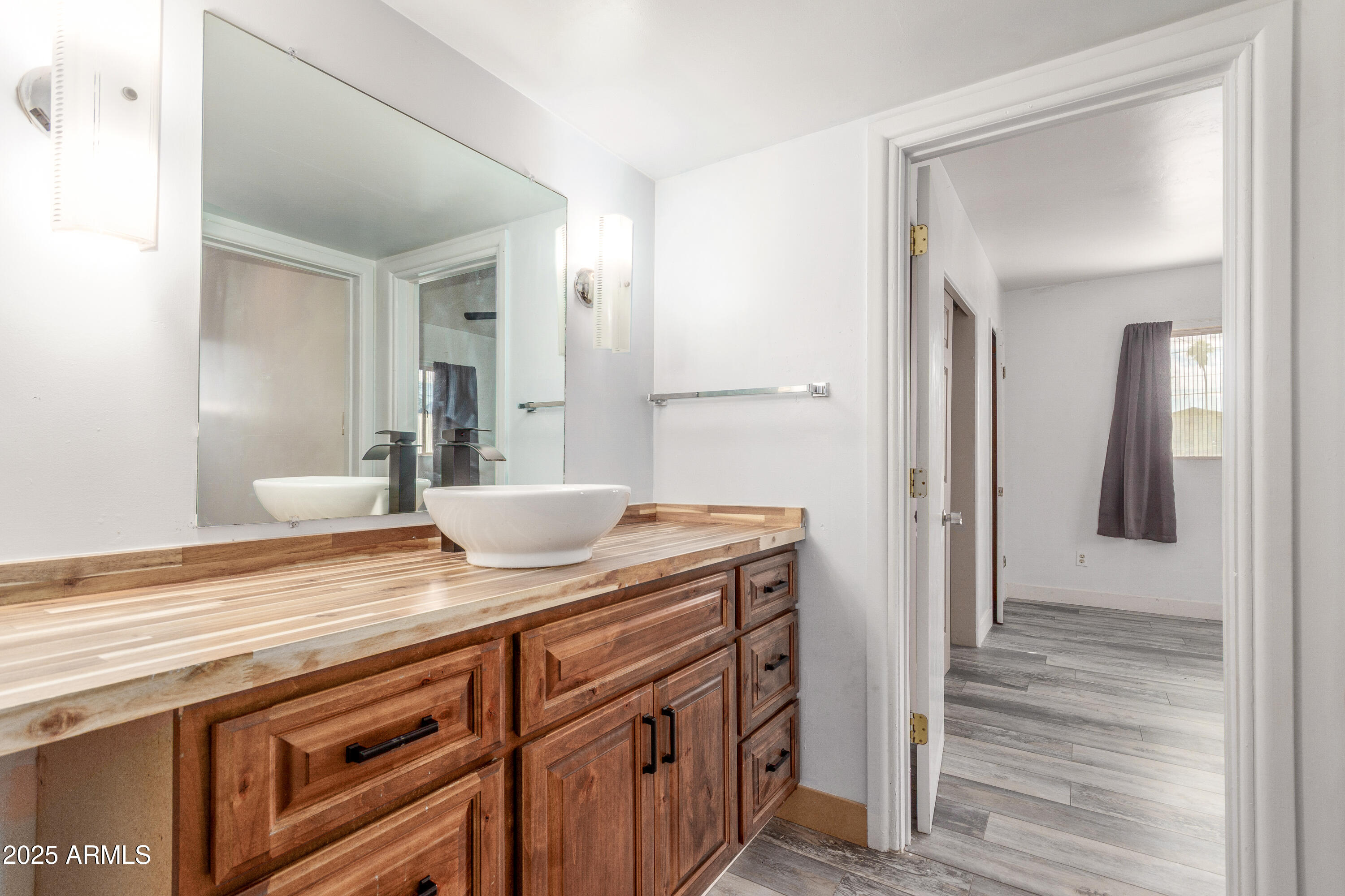 413 East 3rd Street Eloy, AZ 85131 - Photo 22 of 44 a view of a bathroom with a sink mirror and wooden floor