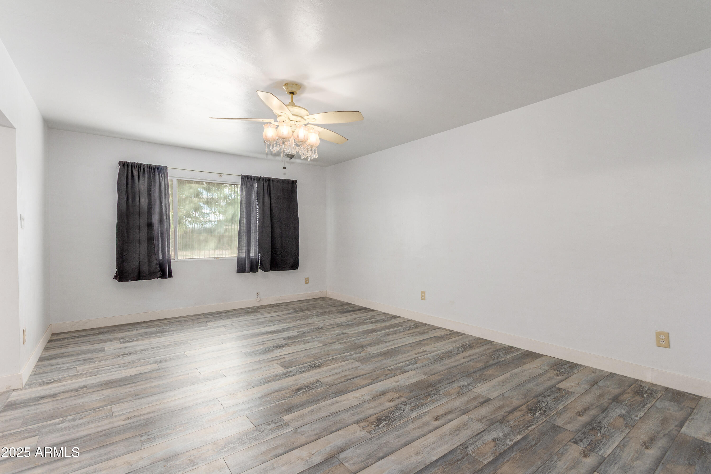 413 East 3rd Street Eloy, AZ 85131 - Photo 7 of 44 a view of an empty room with wooden floor and a window