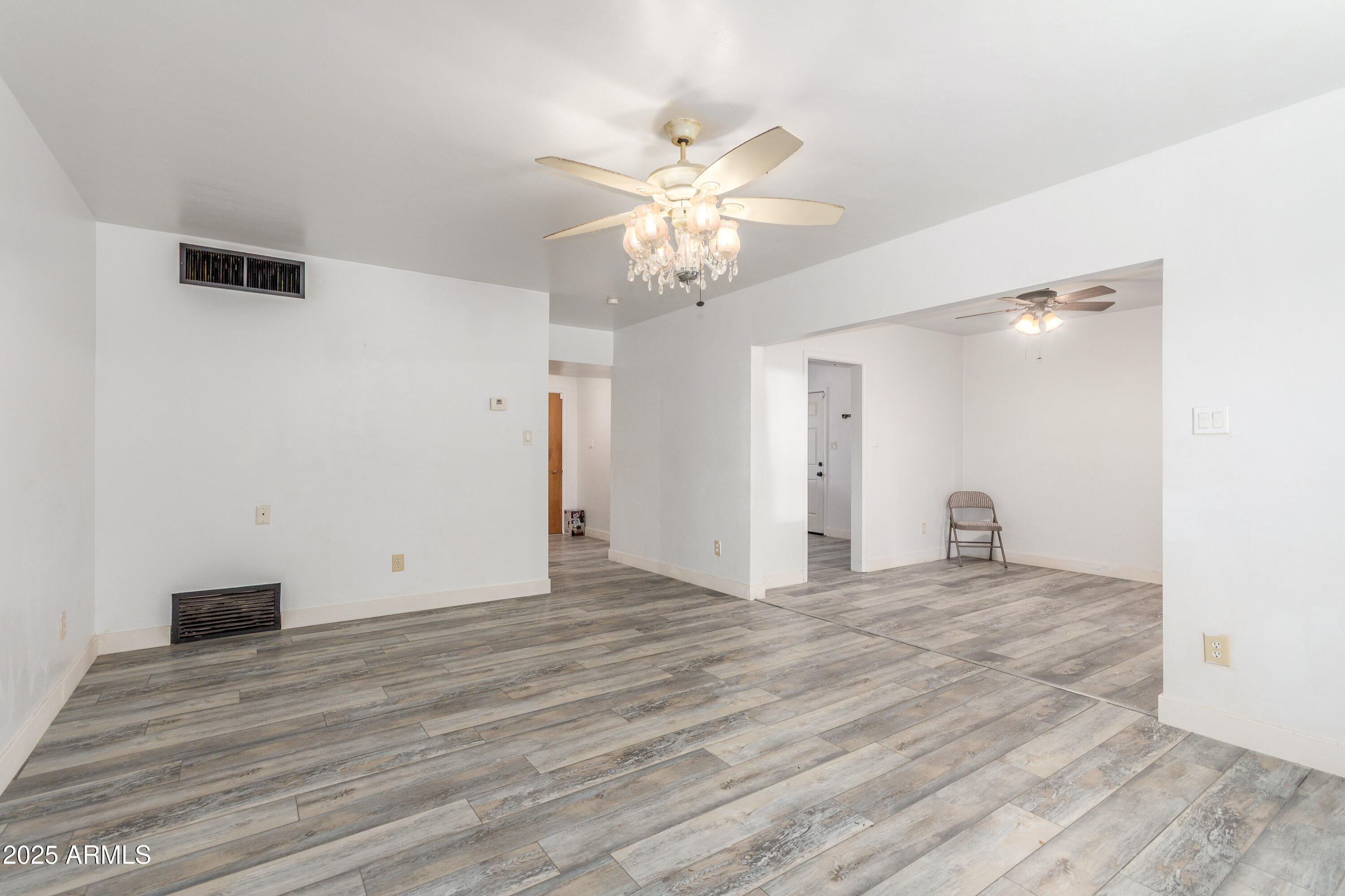413 East 3rd Street Eloy, AZ 85131 - Photo 9 of 44 a view of an empty room with wooden floor and a ceiling fan