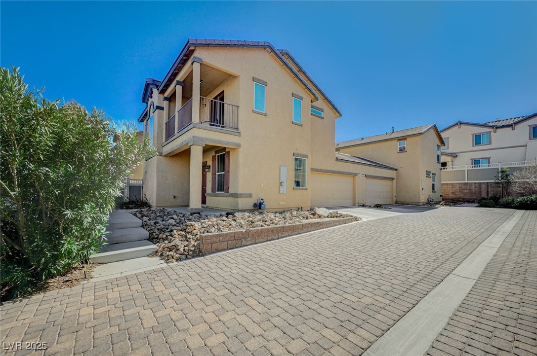 971 Sable Chase Place Henderson, NV 89011 - Photo 1 of 48 View of front facade featuring a balcony, decorative driveway, an attached garage.