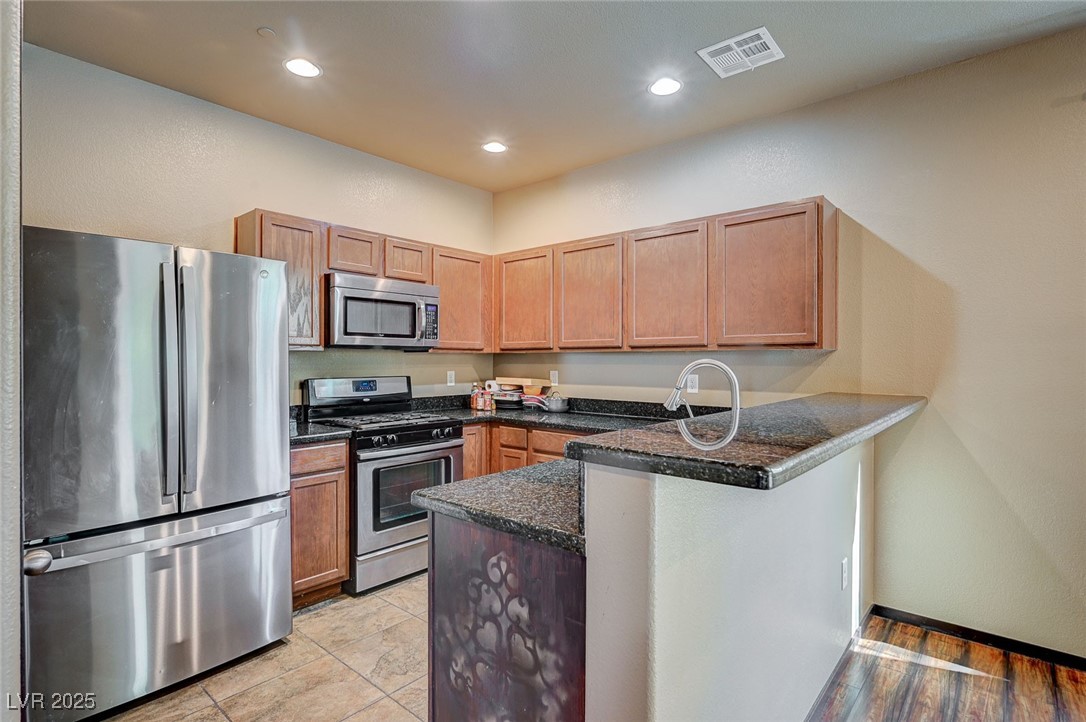 971 Sable Chase Place Henderson, NV 89011 - Photo 13 of 48 Kitchen with recessed lighting, SS appliances breakfast bar and dark oak cabinets