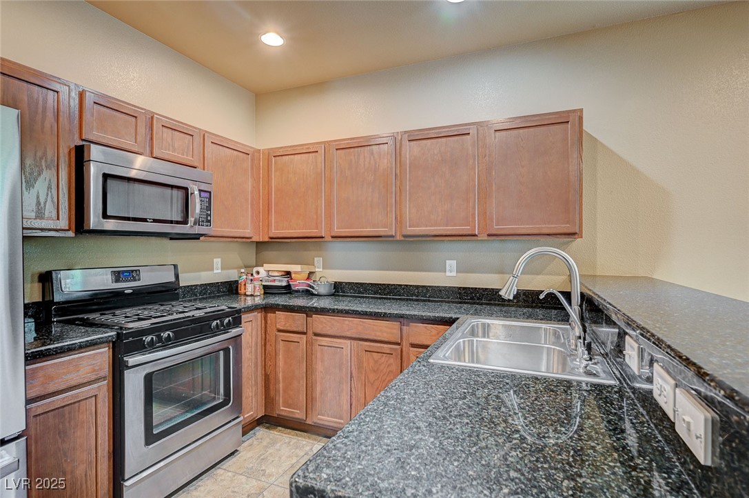 971 Sable Chase Place Henderson, NV 89011 - Photo 14 of 48 Kitchen featuring a sink, dark granite, SS appliances, and recessed lighting