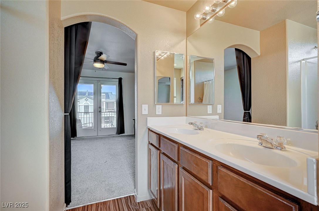 971 Sable Chase Place Henderson, NV 89011 - Photo 25 of 48 Bathroom with double vanity, french doors, a ceiling fan, and a sink