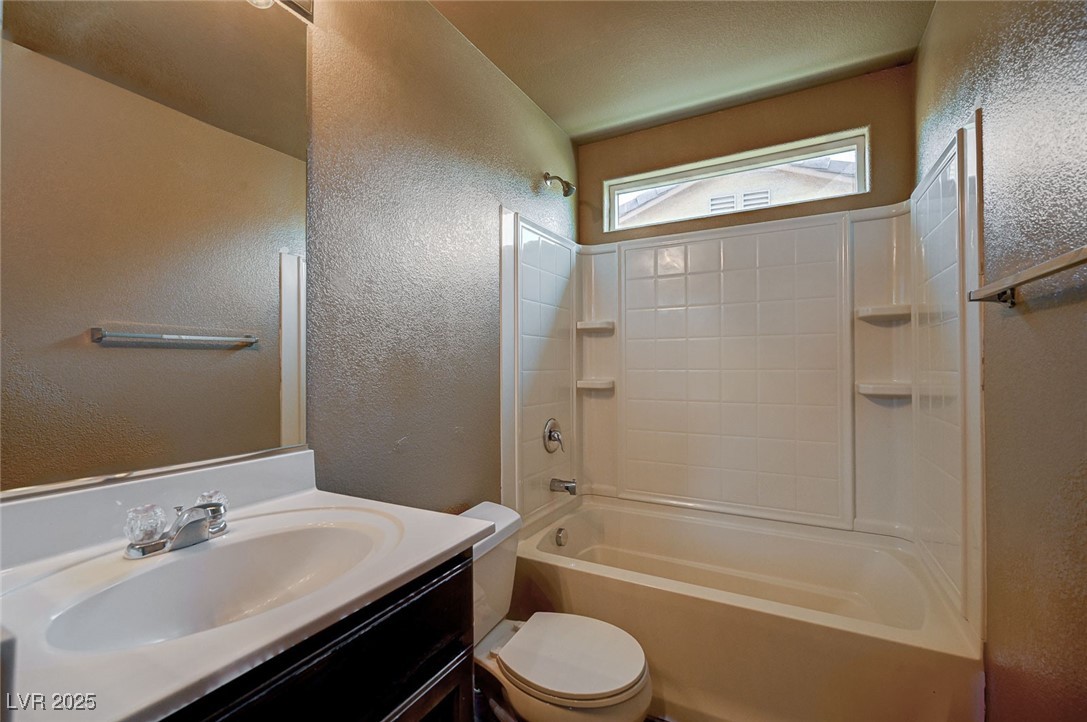 971 Sable Chase Place Henderson, NV 89011 - Photo 32 of 48 Full guest bathroom with shower / bath combination, toilet, vanity, and a textured wall