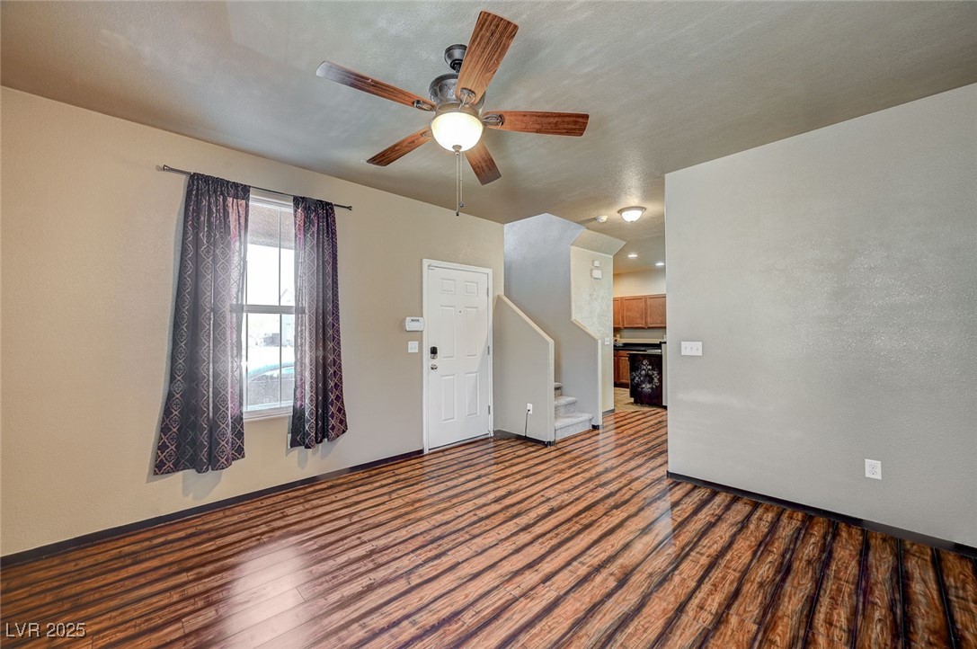 971 Sable Chase Place Henderson, NV 89011 - Photo 7 of 48 Lliving room featuring stairway, LVP floors, and a ceiling fan, just off front door