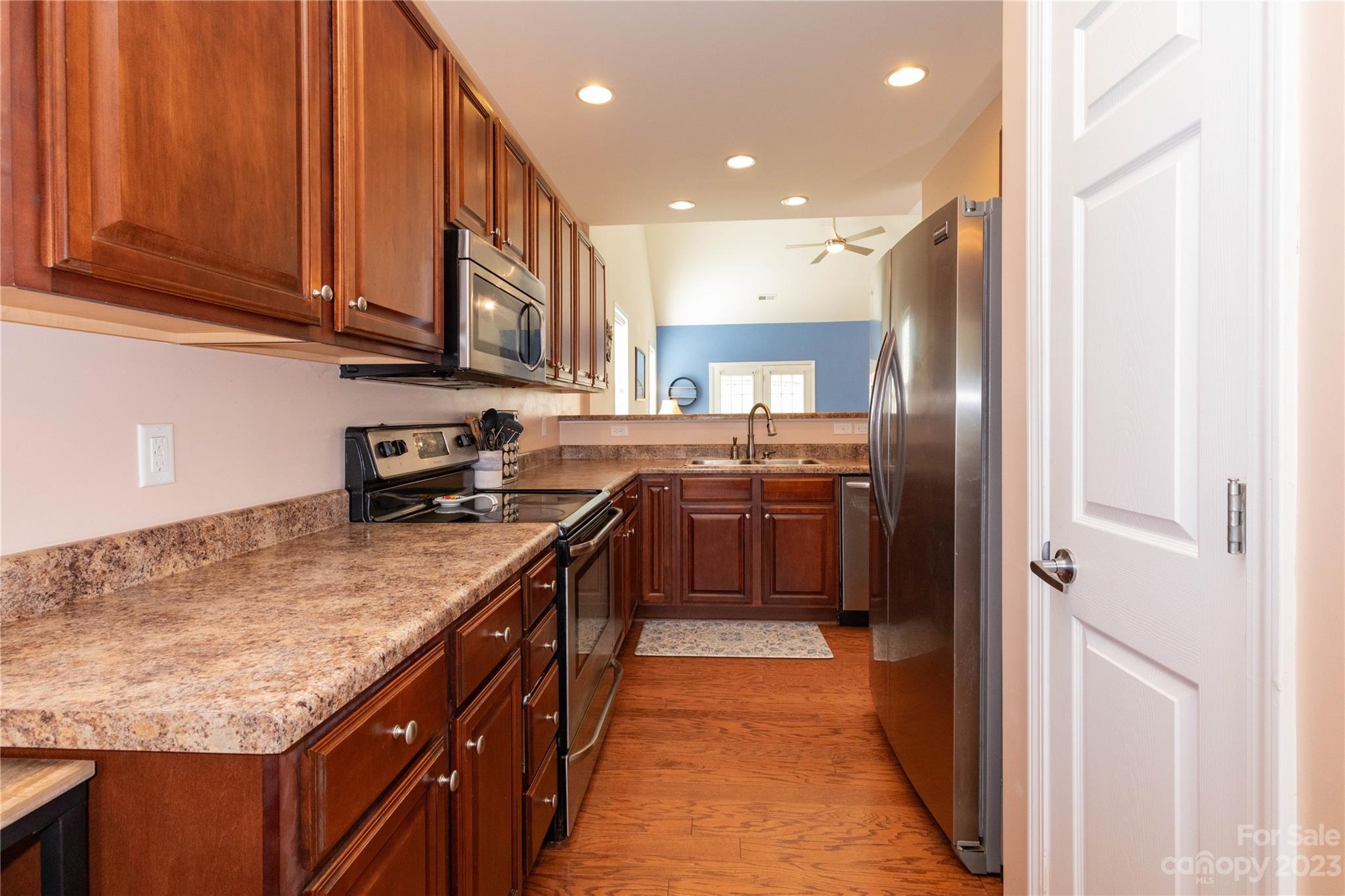 101 Ledbetter Road Arden, NC 28704 - Photo 4 of 21 a kitchen with stainless steel appliances granite countertop a refrigerator a sink dishwasher and wooden cabinets with wooden floor