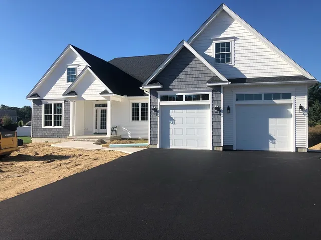a front view of a house with yard and parking