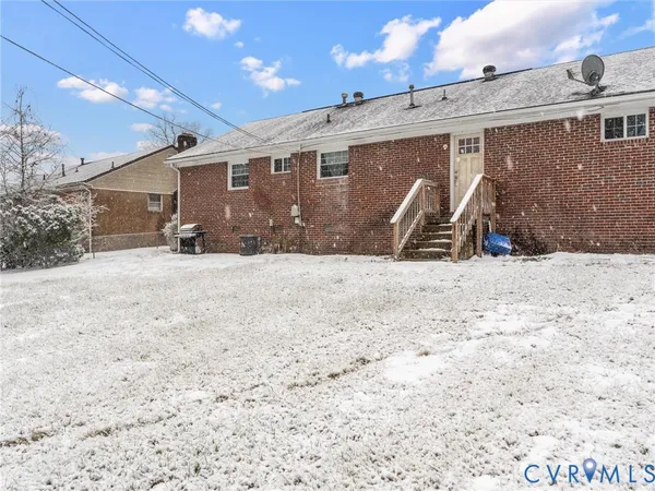 a view of a house with a yard and covered with snow