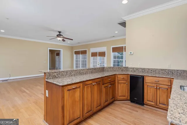 a view of a livingroom with furniture a fireplace wooden floor and a ceiling fan